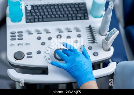 Ultraschallgerät mit der Hand des Arztes in einem blauen Handschuh, Nahaufnahme Stockfoto