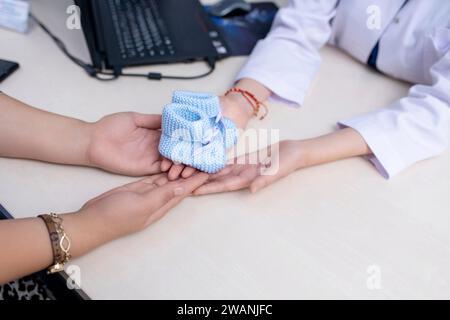 Der Arzt übergibt dem Patienten in der in-vitro-Fertilisationsklinik Stiefel Stockfoto