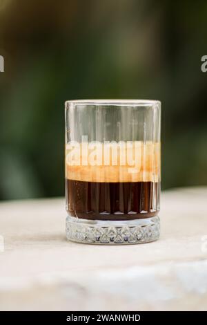 Schokoladenkeks und Kaffee in Glasbecher auf rustikalem Holzhintergrund. Nahaufnahme. Stockfoto