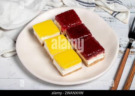 Kleine Käsekuchen. Kleiner Zitronen- und Himbeerkuchen auf weißem Hintergrund Stockfoto