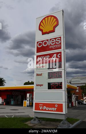 Großes Schild vor einer Tankstelle und einem Supermarkt von Shell Coles Express mit Firmenlogos und aktuellen Kraftstoffpreisen in Cent Stockfoto