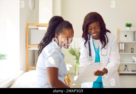 Junge afroamerikanische Frau ist bereit, Krankenversicherungsvertrag mit Hausarzt zu unterzeichnen. Stockfoto