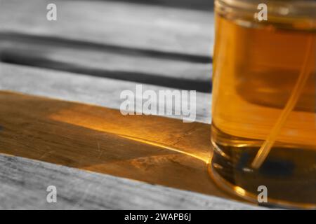 Bunte Reflexe einiger Flaschen auf einem Holztisch Stockfoto