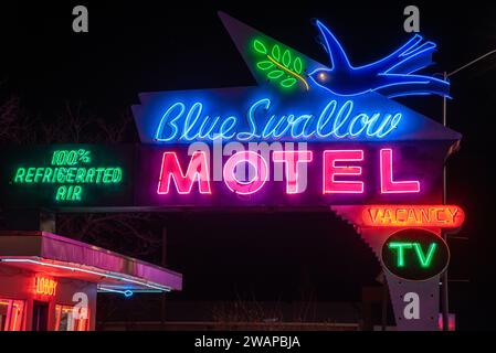 Nahaufnahme des beleuchteten, farbenfrohen Neonschildes auf der Route 66 für Blue Swallow Motel, freie Werbung und 100 % Kühlluft, Tucumcari, New Mexico, USA. Stockfoto