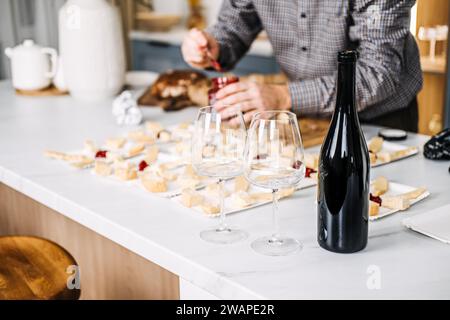 Vorbereitung der Weinprobe mit Käse-Paarungen. Der Sommelier bereitet sich auf eine Weinverkostung vor, bei der sorgfältig verschiedene Käsesorten mit Weinen kombiniert werden Stockfoto