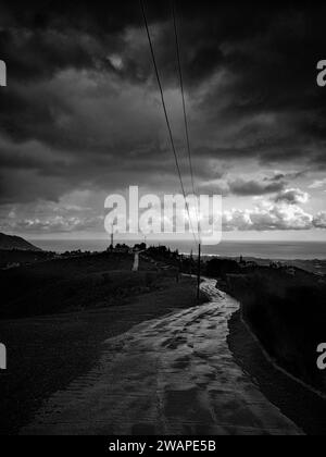 Der Regen in Spanien zieht über die Mittelmeerküste. Bei schlechten Lichtverhältnissen, einer Straße durch die Hügel, die nach Nerja an der Costa del Sol führt, Stockfoto