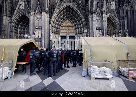 Polizisten rund um den Kölner Dom. Terroralarm zum Jahreswechsel: Nachdem Silvester rund um den Kölner Dom 1000 Polizisten auch mit Maschinenpistolen im Einsatz waren, werden die Sicherheitsregeln weiter aufrecht erhalten. Es gelten verstärkte Sicherheitsmaßnahmen nach einer Terrorwarnung vor Weihnachten. Hintergrund: Eine islamistische Terrorzelle des afghanischen ISIS-Ablegers ISPK soll über den Jahreswechsel u.a. in Köln Anschläge geplan haben. Für Touristen bleibt der Dom weiter geschlossen. Besucher von Messen oder lange im Vorfeld gebuchten Führungen müssen ein Screening in Zelten durchl Stockfoto