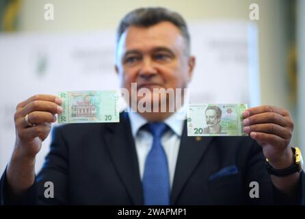 Männlicher Assistent, der eine neue Banknote mit der Stückelung 20 UAH zeigt, die von der Nationalbank der Ukraine ausgegeben wurde. Juli 2018. Kiew, Ukraine Stockfoto