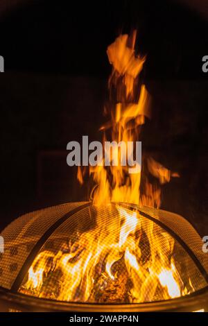 Eine vertikale Nahaufnahme eines brennenden Lagerfeuers vor dunklem Hintergrund Stockfoto