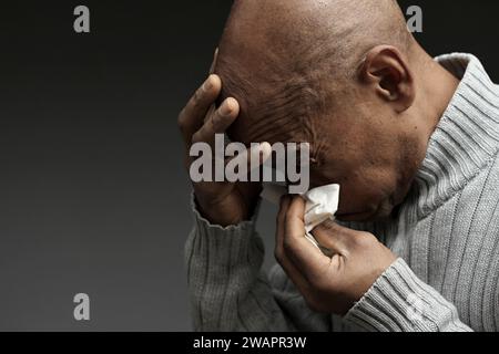 Blasen der Nase nach dem Fangen der Erkältung und Grippe mit grauem Hintergrund mit Menschen Stockfoto Stockfoto