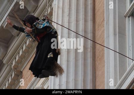 Caserta, Italien. Januar 2024. Ein als Befana getarnter Feuerwehrmann senkt sich von der Fassade des Königspalastes von Caserta ab und schenkt allen Kindern Süßigkeiten und Bonbons zum Abschluss der Weihnachtsfeiertage. Caserta, Italien, 6. Januar 2024. (Foto: Vincenzo Izzo/SIPA USA) Credit: SIPA USA/Alamy Live News Stockfoto