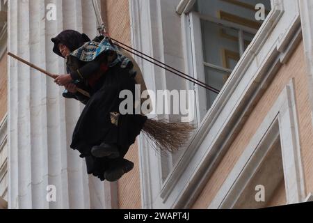 Caserta, Italien. Januar 2024. Ein als Befana getarnter Feuerwehrmann senkt sich von der Fassade des Königspalastes von Caserta ab und schenkt allen Kindern Süßigkeiten und Bonbons zum Abschluss der Weihnachtsfeiertage. Caserta, Italien, 6. Januar 2024. (Foto: Vincenzo Izzo/SIPA USA) Credit: SIPA USA/Alamy Live News Stockfoto