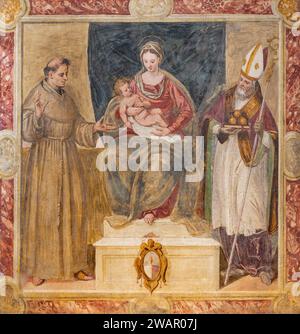 TREVISO, ITALIEN - 4. NOVEMBER 2023: Das Fresko der Madonna mit dem Heiligen Franziskus von Assisi und St. Nikolaus in der Kirche Chiesa di San Francesco (1570). Stockfoto