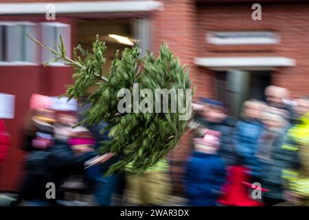 Cottbus, Deutschland. Januar 2024. Ein Baum fliegt während des traditionellen Weihnachtsbaumwurfwettbewerbs der Feuerwehr Ströbitz durch die Luft (Langbelichtungsaufnahme). Mehr als 80 Besucher nahmen am Wettbewerb im Cottbuser Stadtteil Ströbitz Teil, bei dem der Gewinner diejenige ist, die am weitesten einen Weihnachtsbaum werfen kann. Vorher konnten sie zusammen mit anderen Besuchern eine Mahlzeit genießen. Der Erlös aus der Veranstaltung wird an eine soziale Einrichtung in der Stadt Cottbus gespendet. Kredit: Frank Hammerschmidt/dpa/ZB/dpa/Alamy Live News Stockfoto