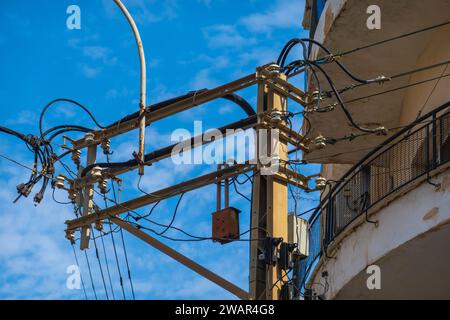 Komplexes Netz aus Stromleitungen und Transformatoren vor klarem blauem Himmel Stockfoto