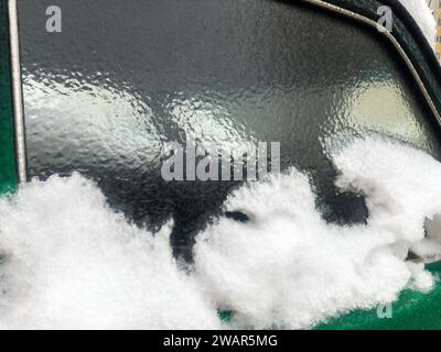 Die Seitenscheibe des Fahrzeugs ist mit Eiskruste bedeckt Stockfoto