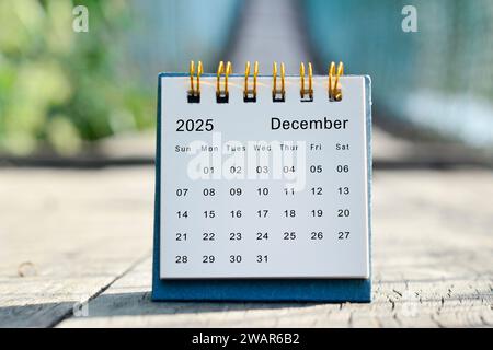 Weißer Kalender für Dezember 2025 mit grünem, verschwommenem Hintergrund. Neujahrskonzept. Stockfoto