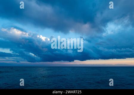 Farbenfroher Sonnenuntergang auf dem Meer. Bergsee in den Strahlen der orangen Sonne. Kirgisistan, Issyk-Kul-See. Natürlicher Hintergrund. Querformat Stockfoto