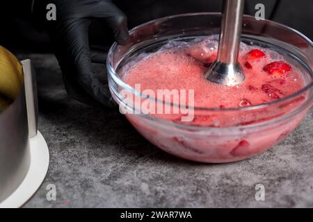 Verrühren Sie Erdbeeren mit Zucker in einem Mixer. Nahaufnahme Stockfoto