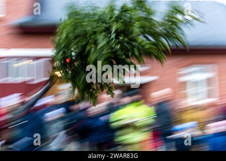 Cottbus, Deutschland. Januar 2024. Ein Baum fliegt während des traditionellen Weihnachtsbaumwurfwettbewerbs der Feuerwehr Ströbitz durch die Luft (Langbelichtungsaufnahme). Mehr als 80 Besucher nahmen am Wettbewerb im Cottbuser Stadtteil Ströbitz Teil, bei dem der Gewinner diejenige ist, die am weitesten einen Weihnachtsbaum werfen kann. Vorher konnten sie zusammen mit anderen Besuchern eine Mahlzeit genießen. Der Erlös aus der Veranstaltung wird an eine soziale Einrichtung in der Stadt Cottbus gespendet. Kredit: Frank Hammerschmidt/dpa/ZB/dpa/Alamy Live News Stockfoto