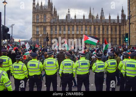 London, England, Großbritannien. Januar 2024. Polizisten beobachten Demonstranten, die auf der Straße sitzen und die Westminster Bridge blockieren. Tausende Demonstranten marschierten in Westminster und forderten einen Waffenstillstand, während der Krieg zwischen Israel und Hamas fortgesetzt wird. (Kreditbild: © Vuk Valcic/ZUMA Press Wire) NUR REDAKTIONELLE VERWENDUNG! Nicht für kommerzielle ZWECKE! Quelle: ZUMA Press, Inc./Alamy Live News Stockfoto