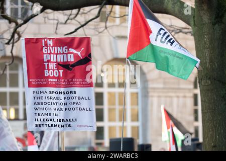 Manchester, Großbritannien. Januar 2024. Unterzeichnen Kritik an Pumas Unterstützung für die israelische Politik. Demonstranten in Manchester Großbritannien gegen den Krieg in Gaza. Palästinensische Proteste im Zentrum von Manchester. UK. Über zweitausend Demonstranten versammelten sich auf dem Petersplatz und forderten einen Waffenstillstand. Sie marschierten dann durch das Stadtzentrum. Die Polizei bewachte Filialen, von denen die Demonstranten sagten, dass sie Verbindungen zu Israel hatten, einschließlich Barclays Bank und Starbucks Coffee. Die Demonstranten schwenkten Fahnen und trugen Plakate mit Slogans gegen den Krieg. Manchester UK. Bild: Garyroberts/worldwidefeatures.com Credit: GaryRobertsphotography/Alamy Live N Stockfoto