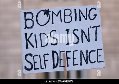 Manchester, Großbritannien. Januar 2024. Kinder zu bombardieren ist kein Selbstverteidigungsschild. Demonstranten in Manchester, Großbritannien, gegen den Krieg in Gaza. Palästinensische Proteste im Zentrum von Manchester. UK. Über zweitausend Demonstranten versammelten sich auf dem Petersplatz und forderten einen Waffenstillstand. Sie marschierten dann durch das Stadtzentrum. Die Polizei bewachte Filialen, von denen die Demonstranten sagten, dass sie Verbindungen zu Israel hatten, einschließlich Barclays Bank und Starbucks Coffee. Die Demonstranten schwenkten Fahnen und trugen Plakate mit Slogans gegen den Krieg. Manchester UK. Bild: Garyroberts/worldwidefeatures.com Credit: GaryRobertsphotography/Alamy Live News Stockfoto