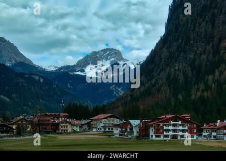 Eine malerische kleine Stadt in Gröden, eingebettet in den Ausläufern einer großen, majestätischen Bergkette. Stockfoto