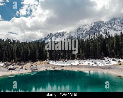 Ein atemberaubender Blick auf einen alpinen See, umgeben von schneebedeckten Bergen und üppigen immergrünen Bäumen Stockfoto