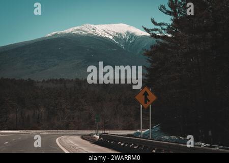 Ein malerischer Blick auf eine leere Bergstraße, die sich durch einen üppigen Kiefernwald schlängelt Stockfoto