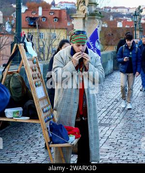 Person, die an einem traditionellen Instrument auf der berühmten Karlsbrücke in Prag singt Stockfoto