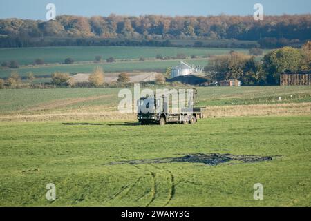 Britische Armee MAN SX 6x6-Tieflader mit Kran auf einem grünen Grasfeld, die CDS-Paletten von einem Fallschirmfallen holen. Wilts UK Stockfoto