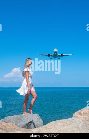 Synchronizing Dreams: Mädchen in weiß trifft auf ein Flugzeug über dem Blauen Meer Stockfoto