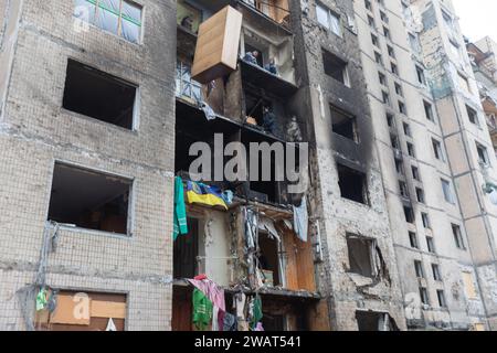 Kiew, Ukraine. Januar 2024. Die Fassade eines Gebäudes nach einem Raketenangriff russischer Truppen. Zerbrochene Fenster und Brandspuren sind zu sehen. Freiwillige werfen beschädigte Gegenstände aus den Fenstern des Gebäudes (Credit Image: © Mykhaylo Palinchak/SOPA Images via ZUMA Press Wire) NUR ZUR REDAKTIONELLEN VERWENDUNG! Nicht für kommerzielle ZWECKE! Stockfoto