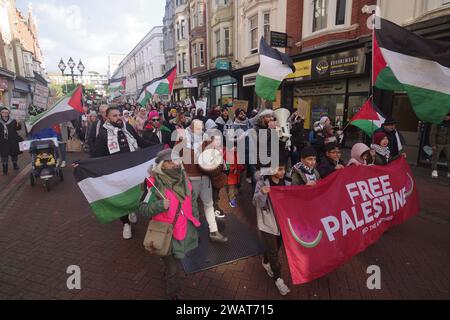 Über 200 marschierten am 6. Januar 2024 durch Bournemouth für eine Waffenruhe in Gaza. Viele in weiß gekleidet und mit Namen von Kindern, die in Gaza getötet wurden, war der marsch ein mächtiges visuelles Bild, das einen Waffenstillstand in Gaza forderte. Der marsch blockierte die Pier Approach Road, wo Rauchfackeln angezündet wurden. Der marsch wurde von Palestine Solidarity Bournemouth organisiert. Stockfoto