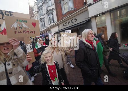 Über 200 marschierten am 6. Januar 2024 durch Bournemouth für eine Waffenruhe in Gaza. Viele in weiß gekleidet und mit Namen von Kindern, die in Gaza getötet wurden, war der marsch ein mächtiges visuelles Bild, das einen Waffenstillstand in Gaza forderte. Der marsch blockierte die Pier Approach Road, wo Rauchfackeln angezündet wurden. Der marsch wurde von Palestine Solidarity Bournemouth organisiert. Stockfoto