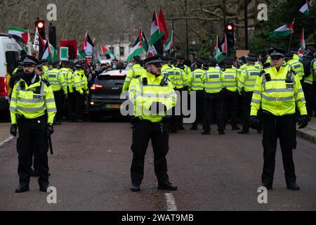 London, Großbritannien. Januar 2024. Polizeibeamte führen Birdcage Walk als Aktivisten der Kundgebung der Freien Palästinensischen Koalition im St. James's Park an, bevor sie zur Westminster Bridge marschierten, um einen sofortigen Waffenstillstand, ein Ende der britischen Waffenverkäufe an Israel und ein Ende der israelischen Besetzung Palästinas zu fordern. Quelle: Ron Fassbender/Alamy Live News Stockfoto