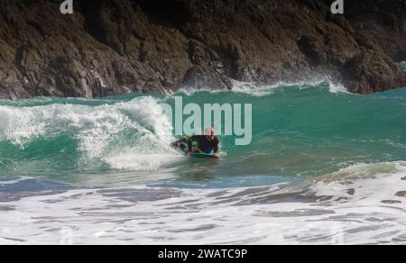 Boarder, der den Break in Kynance Cove, Cornwall, schnappt. Die Welle schneiden. Stockfoto