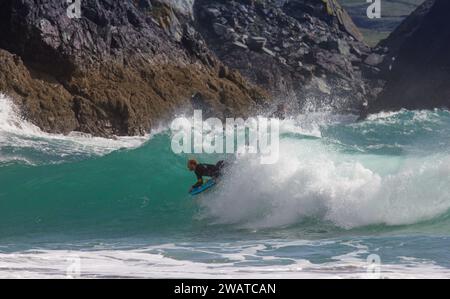 Boarder, der den Break in Kynance Cove, Cornwall, schnappt. Stockfoto