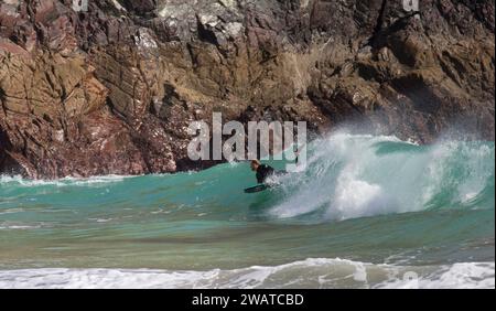 Boarder, der den Break in Kynance Cove, Cornwall, schnappt. Stockfoto