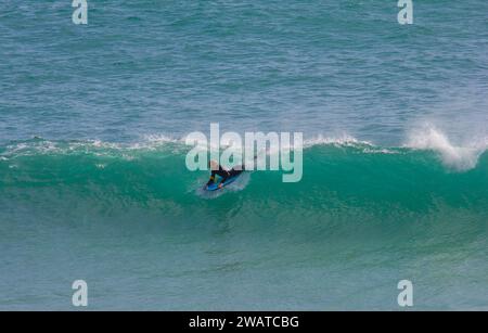 Boarder, der den Break in Kynance Cove, Cornwall, schnappt. Stockfoto