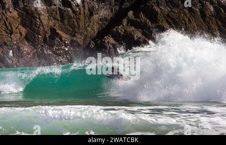 Boarder, der den Break in Kynance Cove, Cornwall, schnappt. Stockfoto