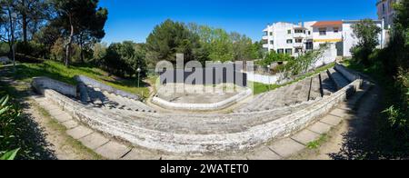 Leeres Amphitheater mit Zementsitzen und schwarzem Bühnenhintergrund im Friedens- und Freundschaftspark in der Stadt Barreiro. Stockfoto