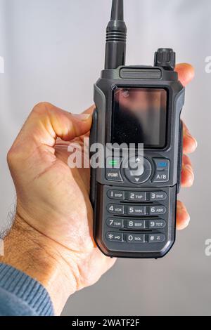 Amateur-Radio-Walkie-Talkie-tragbares Triband in der Hand eines weißen Mannes gehalten Stockfoto