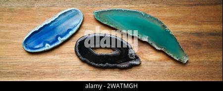 Scheiben von natürlichen Achatsteinen auf der Holzplatte. Stockfoto