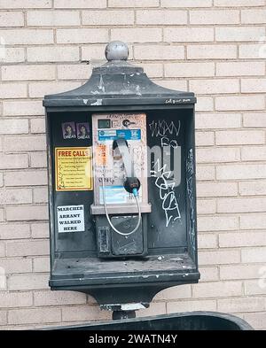 Ein klassisches Münztelefon steht an einer Straße im Zentrum von Pittsburgh, PA, mit Aufklebern und Aufklebern, die darauf warten, dass eine Person einen Anruf tätigt Stockfoto