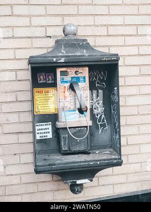 Ein klassisches Münztelefon steht an einer Straße im Zentrum von Pittsburgh, PA, mit Aufklebern und Aufklebern, die darauf warten, dass eine Person einen Anruf tätigt Stockfoto