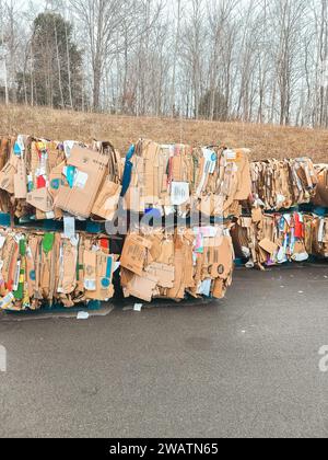 Abgebrochene Kartons werden flach gestapelt und können recycelt und an den Recyclingwagen hinter dem großen Kartonlager geschickt werden Stockfoto