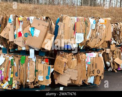 Abgebrochene Kartons werden flach gestapelt und können recycelt und an den Recyclingwagen hinter dem großen Kartonlager geschickt werden Stockfoto