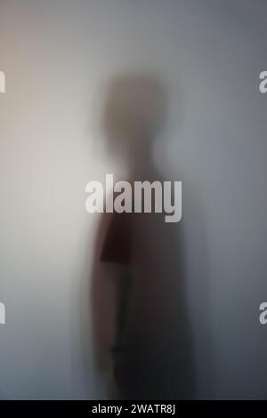 Mann-Silhouette hinter Milchglas Stockfoto